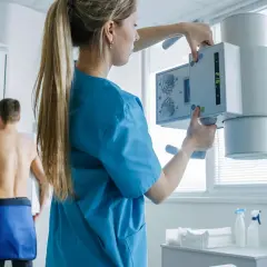 Technik przygotowuje aparat RTG do badania pacjenta. To właśnie RTG co to jest, czyli rentgenografia.
